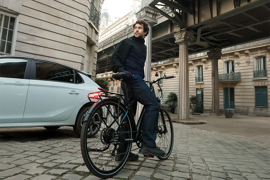 Male rider on modern commuter electric bicycle in historic Paris city street, urban e‑bike daily transportation